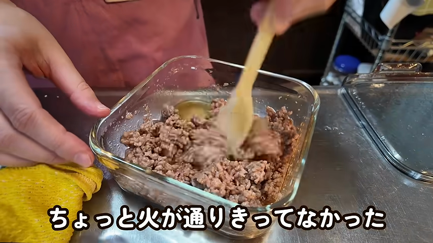 耐熱容器のひき肉をへらでほぐして混ぜる様子