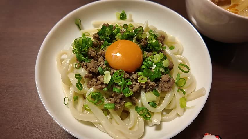 豚ひき肉の肉みそ、小ねぎ、卵黄をのせた月見うどん